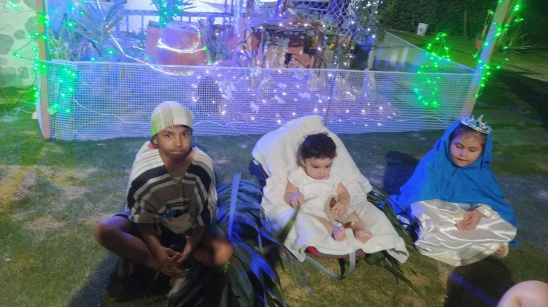 Niños de la familia representando el pesebre en una novena